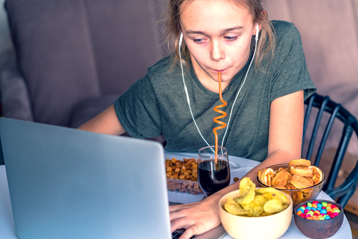 Woman snacking on junk food at her desk
