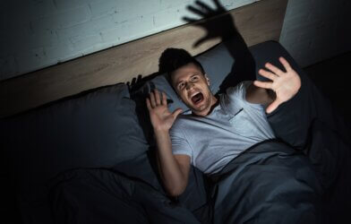 Man screaming from a nightmare in bed