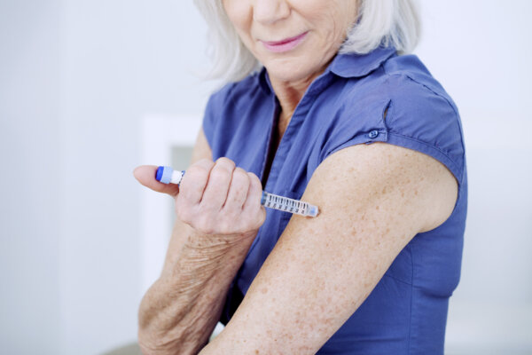 Senior woman injecting herself with insulin.